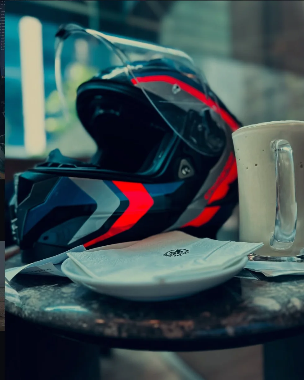 Motorcycle helmet resting on a cafe table beside a cup of tea