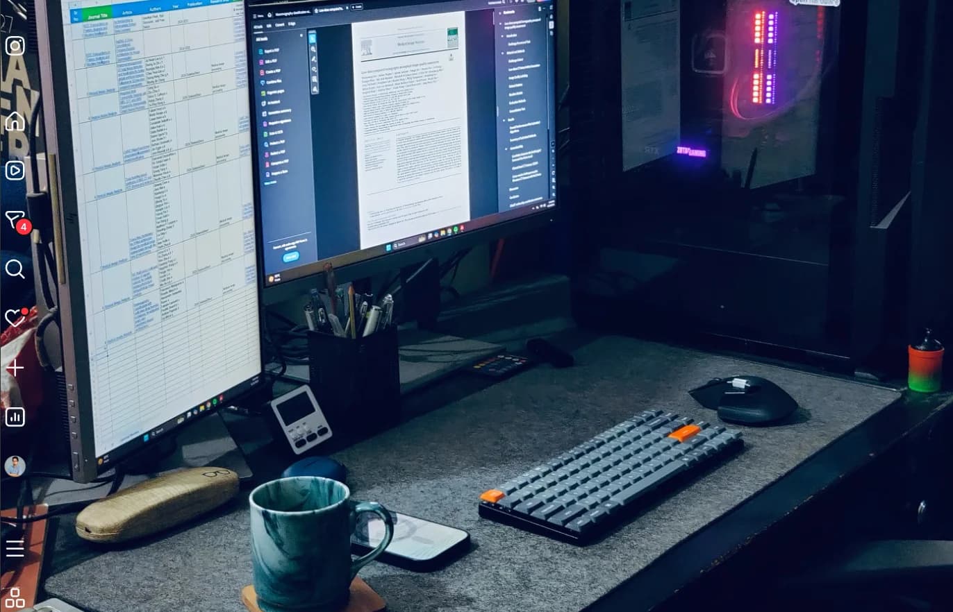 A dual-monitor desk setup at night with warm ambient lighting